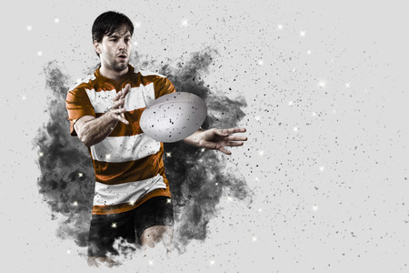 Rugby Player with a orange uniform coming out of a blast of smoke .の写真素材