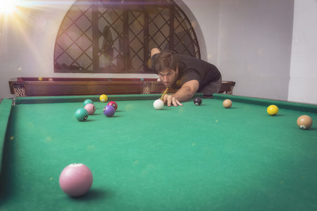 Man playing billiards in a pool table.