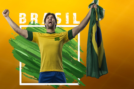 Brazilian soccer player, celebrating on a yellow background with copy space.の写真素材