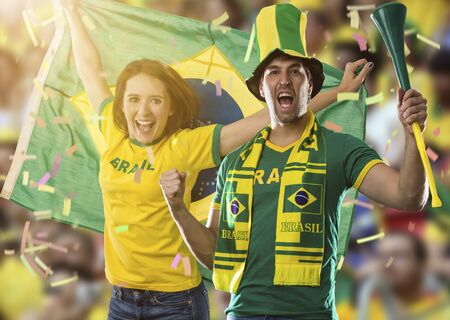 Brazilian couple Celebrating on a stadium on a soccer game, cheering for Brazil to be the champion.の写真素材
