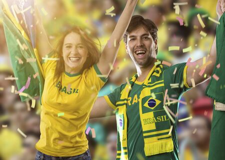 Brazilian couple Celebrating on a stadium on a soccer game, cheering for Brazil to be the champion.の写真素材