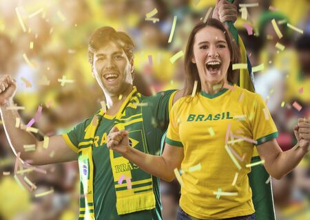 Brazilian couple Celebrating on a stadium on a soccer game, cheering for Brazil to be the champion.の写真素材