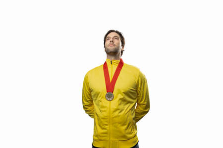 male athlete smiling after winning a gold medal in a white background. Sportsman with medal celebrating his victory.の写真素材