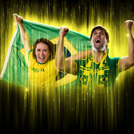 Brazilian couple Celebrating the cup on a black background with yellow glow, cheering for Brazil to be the champion.の写真素材