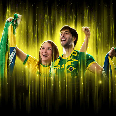 Brazilian couple Celebrating the cup on a black background with yellow glow, cheering for Brazil to be the champion.の写真素材