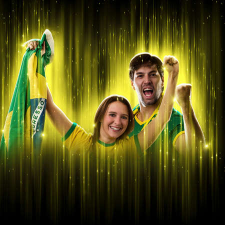 Brazilian couple Celebrating the cup on a black background with yellow glow, cheering for Brazil to be the champion.の写真素材