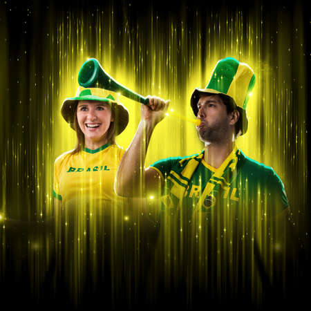 Brazilian couple Celebrating the cup on a black background with yellow glow, cheering for Brazil to be the champion.の写真素材