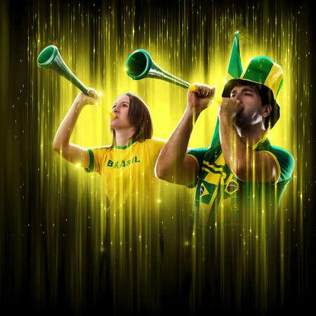 Brazilian couple Celebrating the cup on a black background with yellow glow, cheering for Brazil to be the champion.の写真素材