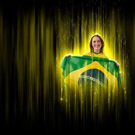 Brazilian woman fan, celebrating on a yellow and black backgroun, cheering for Brazil to be the champion.の写真素材
