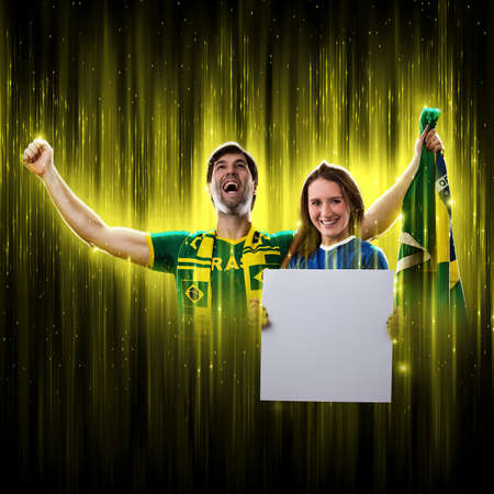 Brazilian couple holding white empty boards on a black background, cheering for Brazil to be the champion.の写真素材