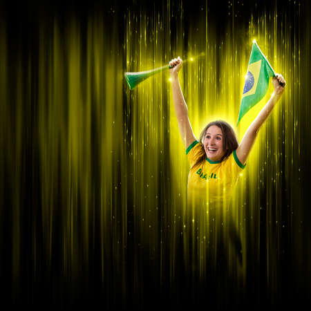 Brazilian woman fan, celebrating on a yellow and black backgroun, cheering for Brazil to be the champion.の写真素材