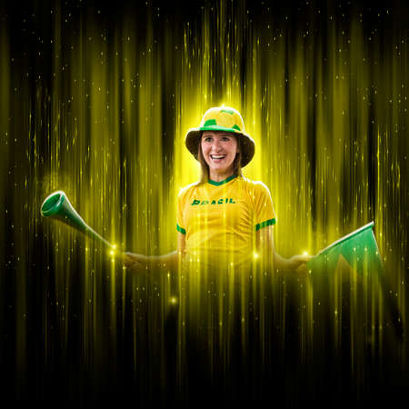 Brazilian woman fan, celebrating on a yellow and black backgroun, cheering for Brazil to be the champion.の写真素材