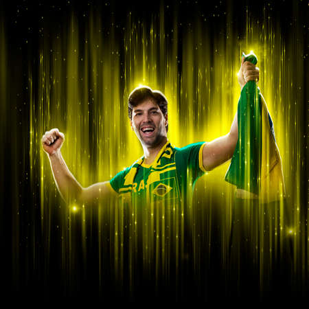 Brazilian fan, celebrating on a yellow and black backgroun, cheering for Brazil to be the champion.の写真素材