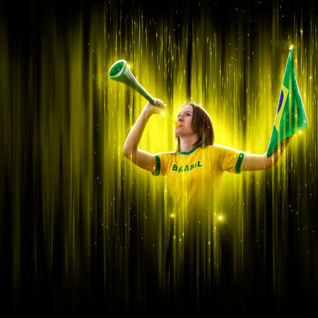 Brazilian woman fan, celebrating on a yellow and black backgroun, cheering for Brazil to be the champion.の写真素材