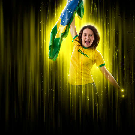 Brazilian woman fan, celebrating on a yellow and black backgroun, cheering for Brazil to be the champion.の写真素材