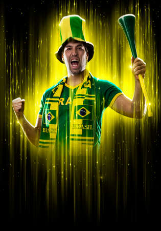 Brazilian fan, celebrating on a yellow and black backgroun, cheering for Brazil to be the champion.の写真素材