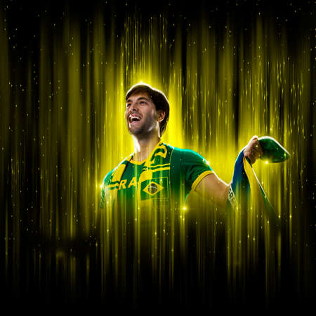 Brazilian fan, celebrating on a yellow and black backgroun, cheering for Brazil to be the champion.の写真素材