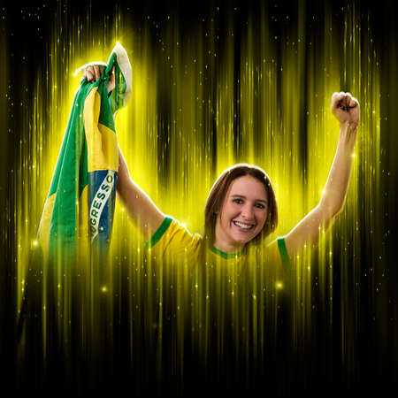 Brazilian woman fan, celebrating on a yellow and black backgroun, cheering for Brazil to be the champion.の写真素材