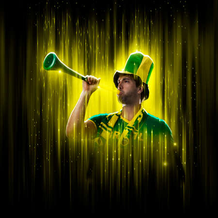 Brazilian fan, celebrating on a yellow and black backgroun, cheering for Brazil to be the champion.の写真素材