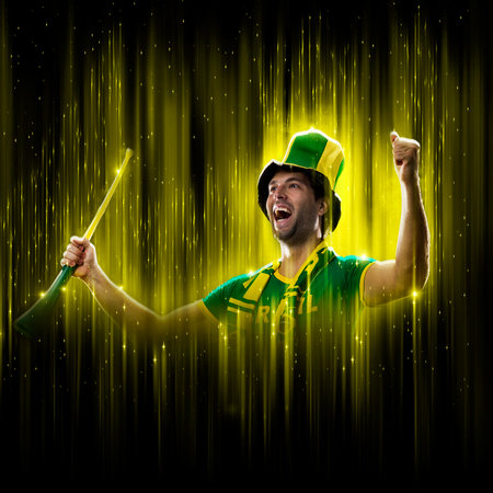 Brazilian fan, celebrating on a yellow and black backgroun, cheering for Brazil to be the champion.の写真素材
