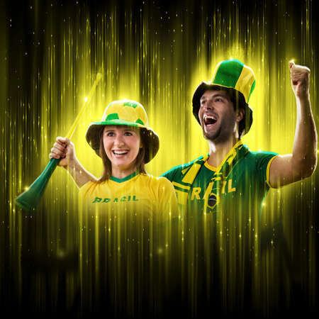 Brazilian couple Celebrating the cup on a black background with yellow glow, cheering for Brazil to be the champion.の写真素材