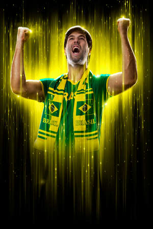 Brazilian fan, celebrating on a yellow and black backgroun, cheering for Brazil to be the champion.の写真素材
