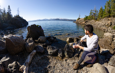 Man on the shores of the lake drinking Argentine mateの写真素材