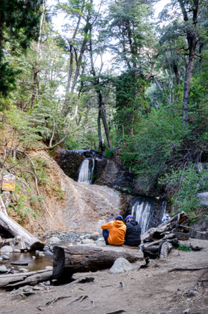 Hiking in the forest with a beautiful waterfall in the background.の写真素材