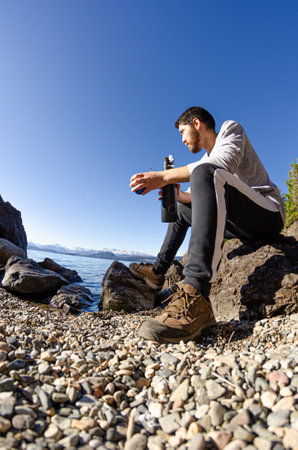 Man on the shores of the lake drinking Argentine mateの写真素材