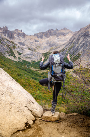 Hike in the mountains. A woman with a backpack walks along the trail.の写真素材