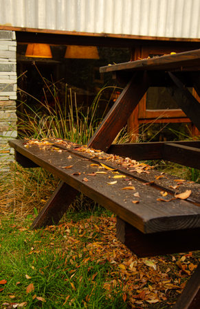 Wooden bench with autumn leaves in the backyard of a country houseの写真素材