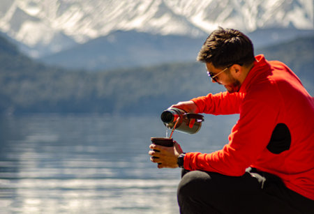 Man on the shores of the lake drinking Argentine mateの写真素材