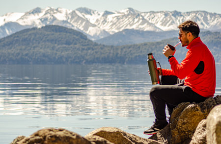Man on the shores of the lake drinking Argentine mateの写真素材
