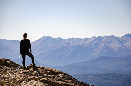 Young man on top of a mountain looking at the beautiful landscape.の写真素材