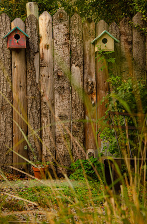 Old wooden fence with birdhouses in the garden. Select focus.の写真素材