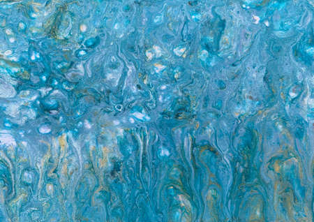 A photograph of an acrylic fluid art painting. Features blue and silver paint to give the effect of water shimmering in the summer sun.の写真素材