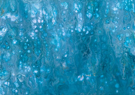 A photograph of an acrylic fluid art painting. Features blue and silver paint to give the effect of water shimmering in the summer sun.の写真素材