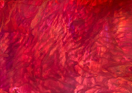 Photograph of fluid acrylic artwork.  The use of red, orange and yellow paint gives the impression of a sunset or fire.の写真素材