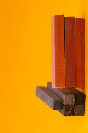 Square colorful pastel chalks tops closeup, on yellow backgroundの写真素材