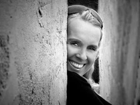 portrait of young flirty lady by a wallの写真素材