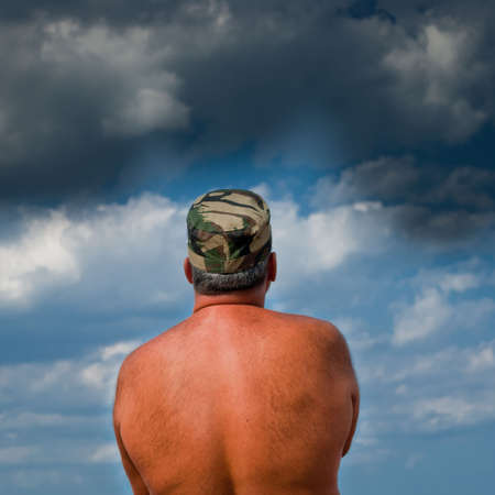Shirtless army man waiting for the storm to come.の写真素材