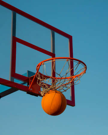 Basketball. The basketball ball hit the basket. This is a victory. Goal achievement and success. This is a win.の写真素材