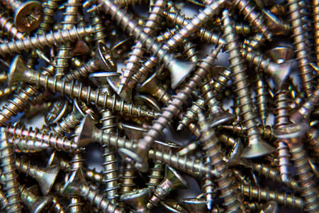 Threaded screws, a bunch. Close-up. Background and textures. Building materials on wood. Fastener. Top view.の写真素材