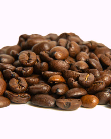 Coffee beans lie on a white background. Isolate. Macro photography. Close-up. Roasted coffee seeds.の写真素材