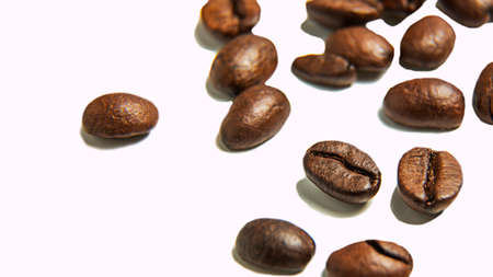 Roasted coffee beans lie on a white background. Isolate. Macro photography. Close-up. Coffee seeds. Arabica.の写真素材