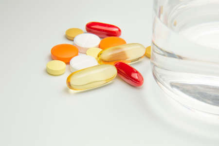 The pills are on the table next to a glass of water. Medicine and healthcare. medicines and vitaminsの写真素材