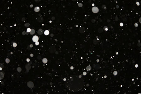 Snowfall at night. White on black. Winter snow backgroundの写真素材