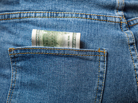 Money, banknotes in a jeans pocket, close up. Money stick out of the jeans pocket, currency and...