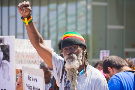 Los Angeles, CA, USA - April 14, 2015:  Man with beard raising hand for justice during Stop Murder by Police. Protest against the brutalization and murdering of black and latino people by police for decades without consequence.のeditorial素材