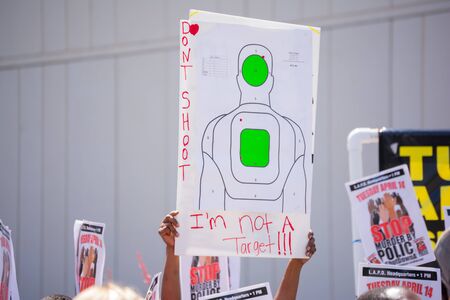 Los Angeles, CA, USA - April 14, 2015:  Person raising sign against human target during Stop Murder by Police. Protest against the brutalization and murdering of black and latino people by police for decades without consequence.のeditorial素材